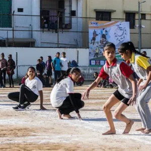 Girls preparing to play kho-kho during inter-school sports event